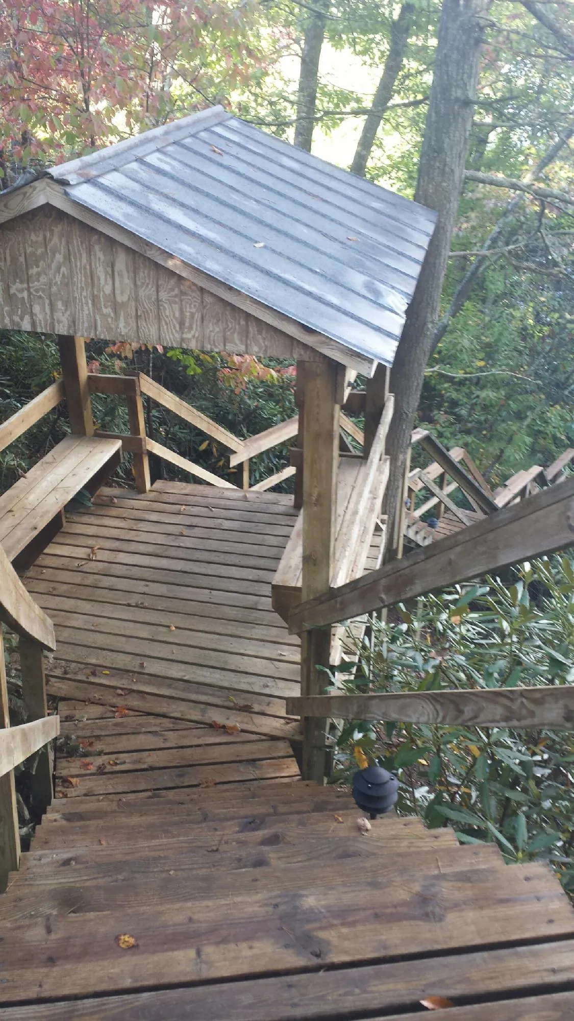 Metal roofed shelter over wooden steps on a wooded walkway — Skylight Repair & Installation work by our crew in Fort Monroe