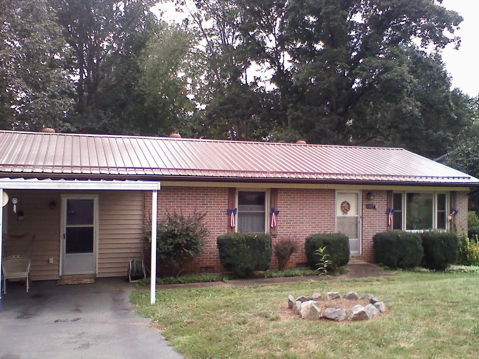 Bronze metal roof and carport on a brick ranch home — Roof Repair work by our crew in Fort Monroe