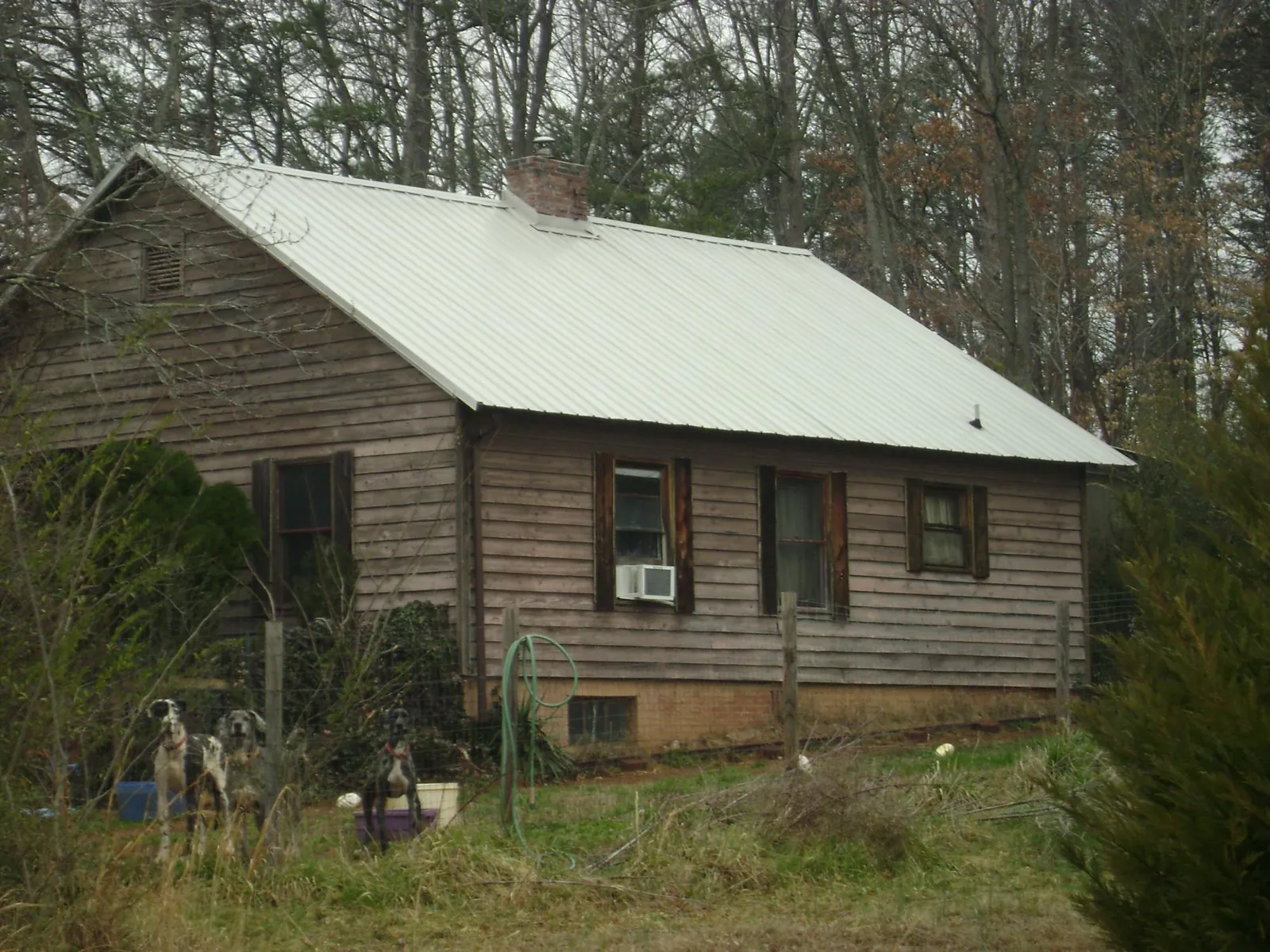 White metal roof on an old wood sided farmhouse, from a Metal Roof Installation job in Fort Monroe